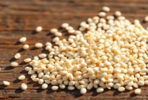 Close-up of high-quality hulled sesame seed spread on a rustic wooden surface, showcasing